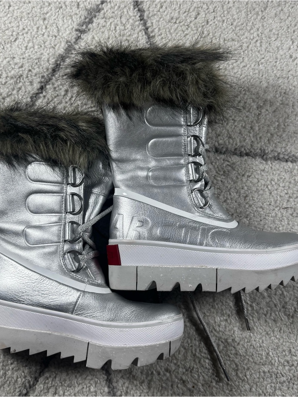 metallic silver Sorel Joan of Arctic Next boots feature a faux fur trim